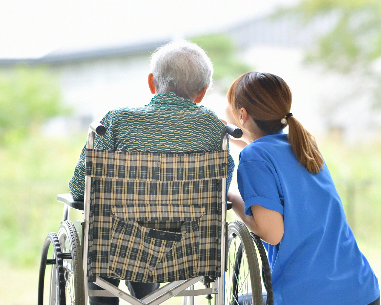車椅子の男性と、介護士の女性